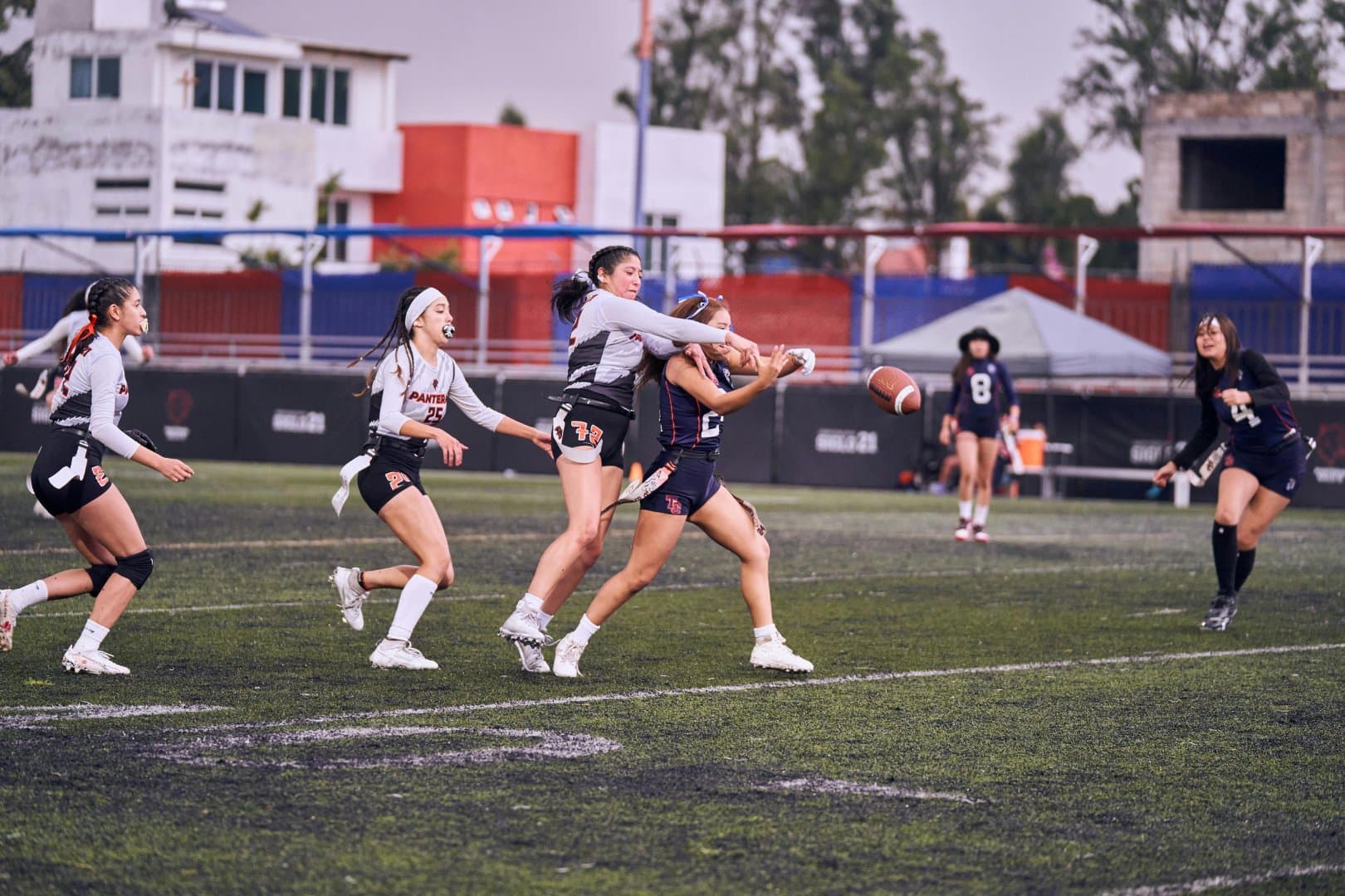 Girls flag football players competing for the ball mid-game