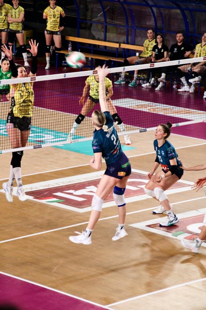 Volleyball player rising for a spike at the net during a match
